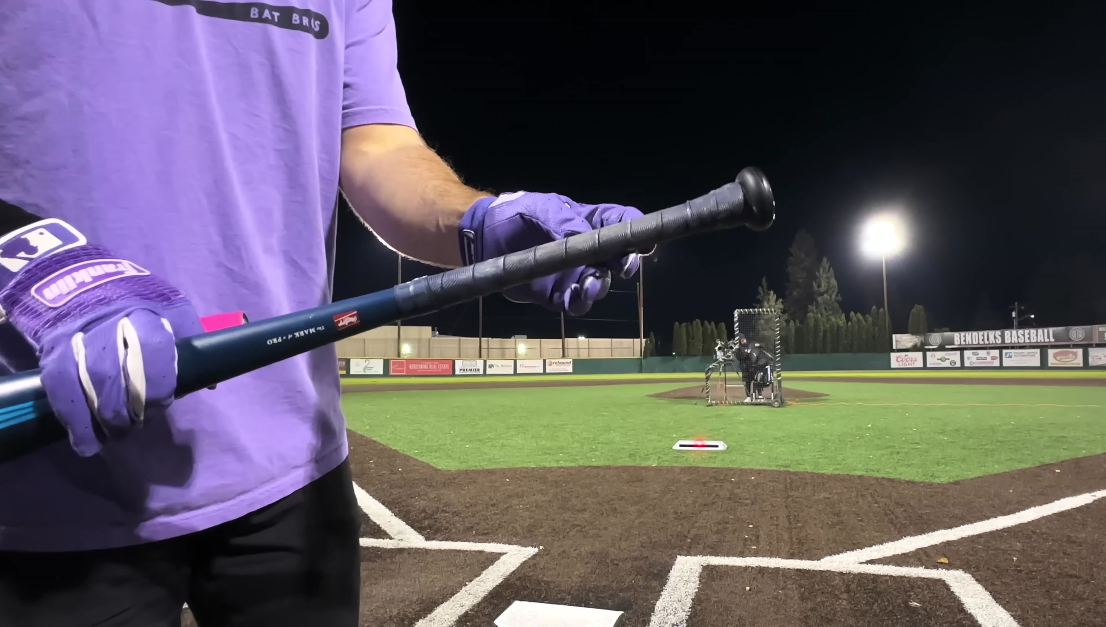 The reviewer demonstrating how a grip can be easily added to the bat's handle.