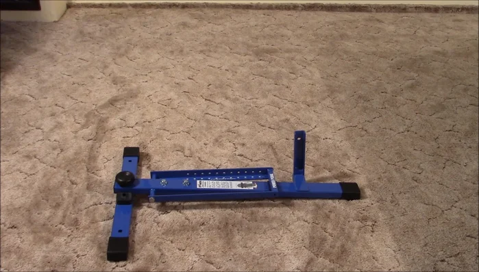 Attach the throwing arm to the base by removing two 9/16 bolts, positioning the throwing arm over the holes, and reinserting the bolts. Tighten the bolts into the frame and then tighten the lock nuts onto the bolts.