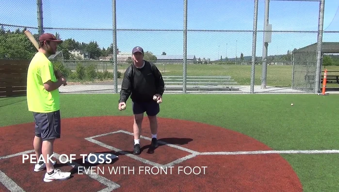 Aim for the middle of the plate, even with the batter's front foot. This ensures the ball travels towards center field, minimizing risk.