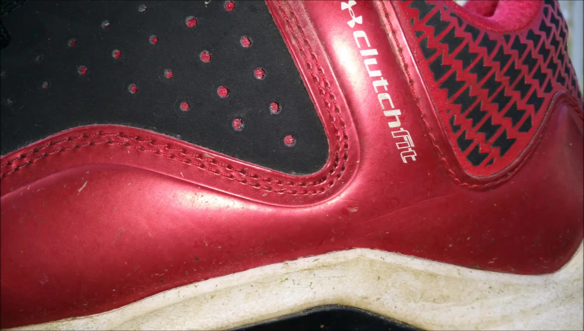 Close-up shot of the shoe's upper, showing the black nubuck material and Under Armour logos.
