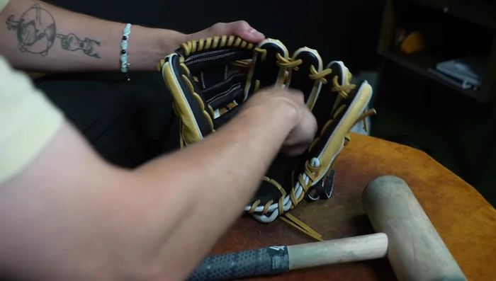 Shape the Pocket: Work the glove to create and shape the pocket, ensuring a proper fit for the youth player's hand. Teach the player to close the glove correctly, aiming for the thumb to meet the pinky and ring fingers.