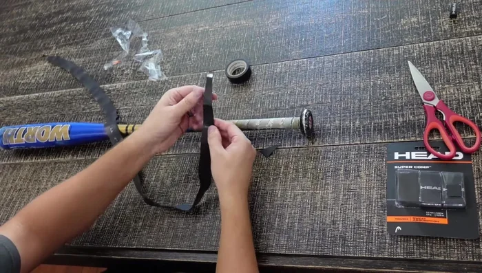 Apply the grip. Align the cut side of the grip parallel to the bat's base. Start wrapping, ensuring full coverage at the base before angling the wrap.