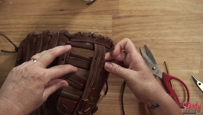 Lace the glove using the chosen lace (Pro Allen or Tandy's Kodiak). Use the large perma lock for larger sections and the small one for smaller sections. Secure the laces using the perma locks; tighten firmly.