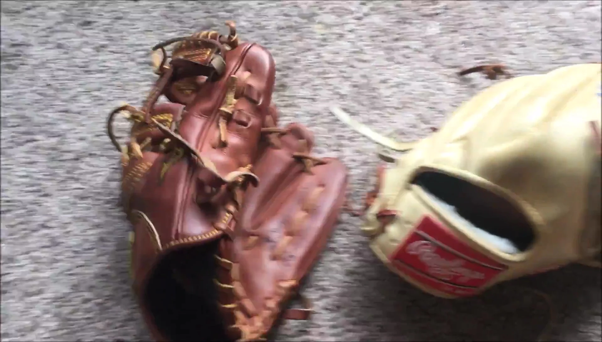 Side-by-side comparison shot of the Rawlings and Mizuno gloves showing stiffness difference.