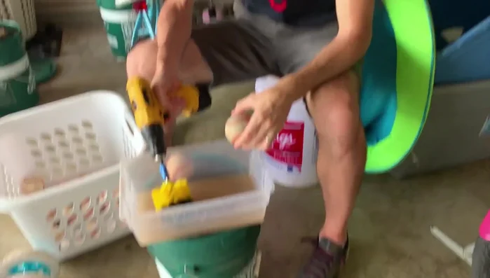 Hold the drill with the brush against the pinched side of the baseball.