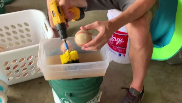 Turn on the drill and let it spin, cleaning the ball.