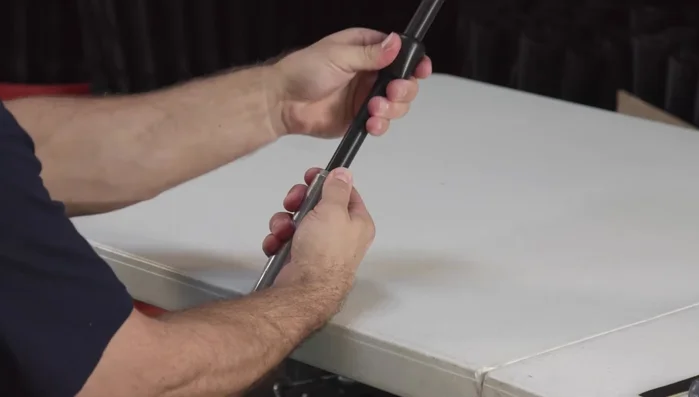 Insert the replacement flex top into the metal pipe. Check the friction by sliding it up and down. Adjust the screw at the base if necessary (one-quarter turn left to loosen, one-quarter turn right to tighten).