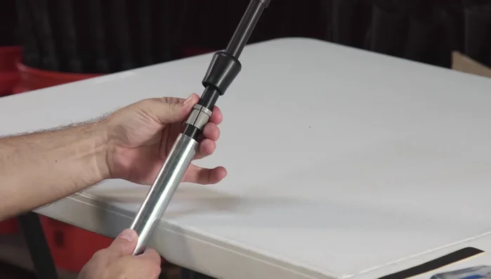 Slide the gray ring down into the metal pipe to form a lip.