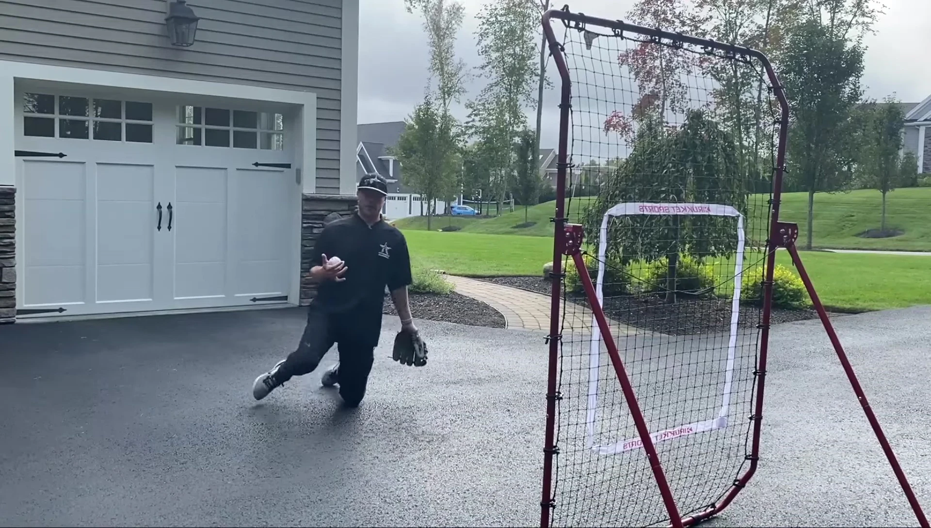 Player demonstrating the two-handed ground ball drill from a kneeling position