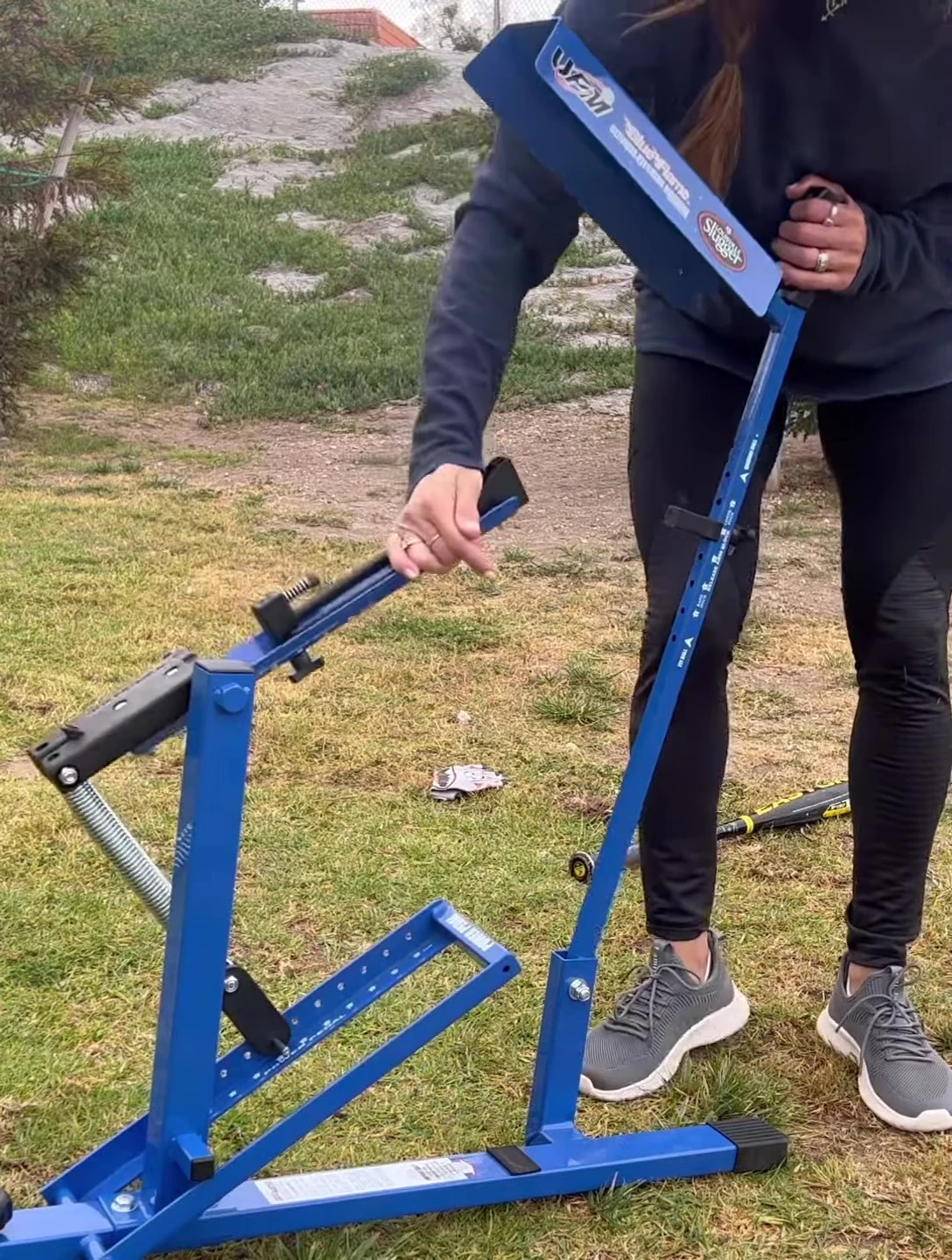 Person demonstrating the simple operation of the pitching machine, holding down the pedal.
