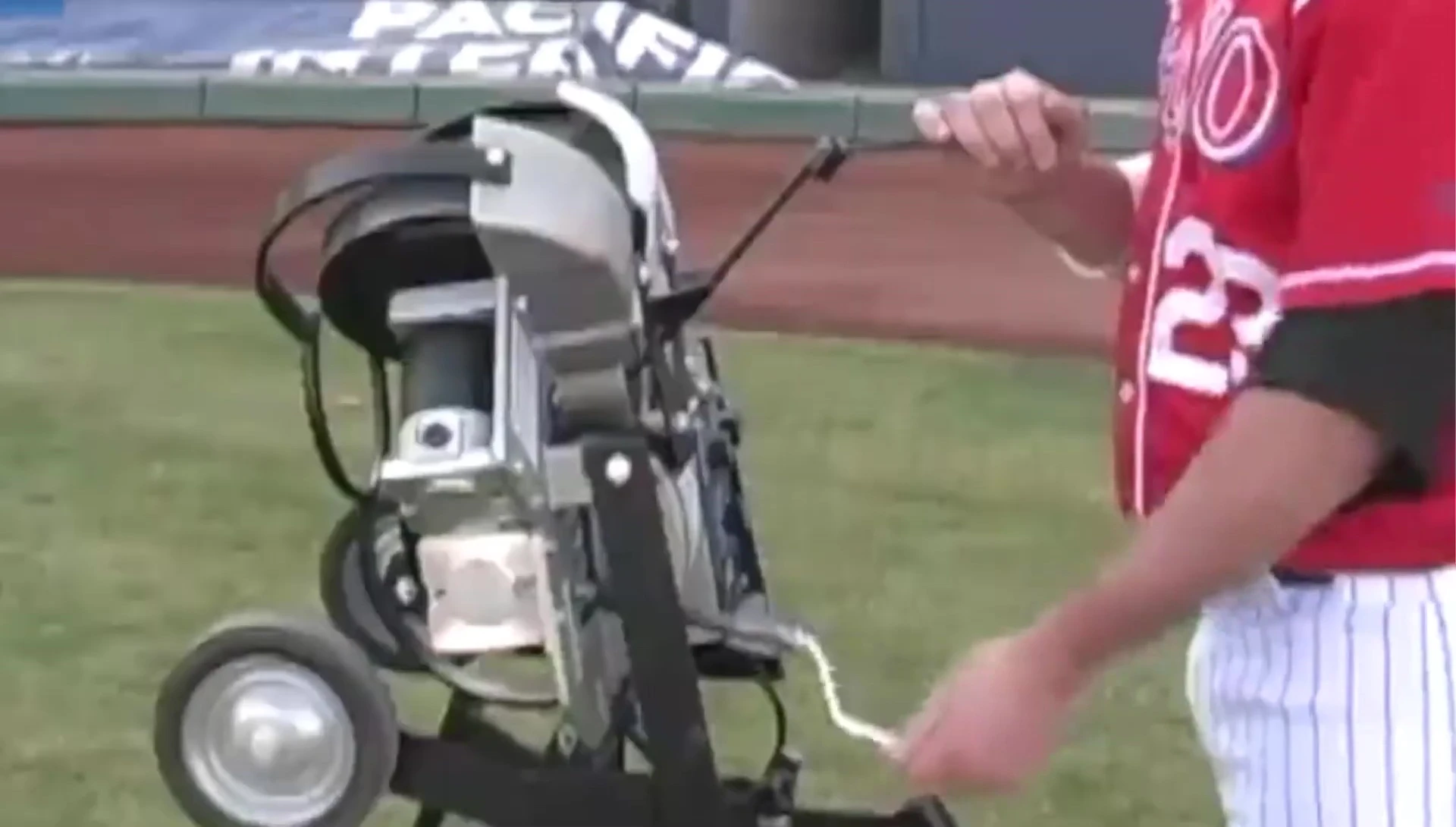 A person using the pitching machine in a practice setting