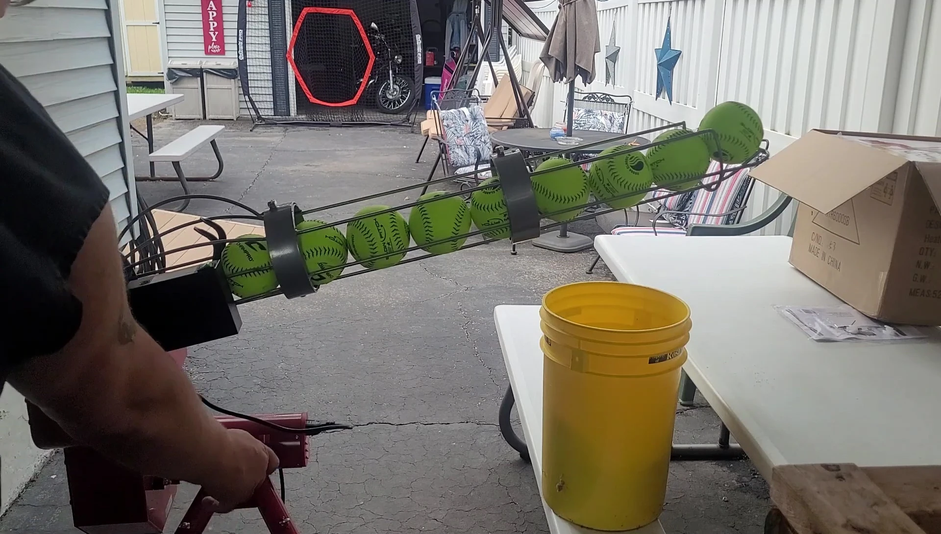 The pitching machine in action, showing the ball being fed and launched.