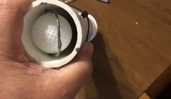 Pulling the trigger forward to launch the projectile.