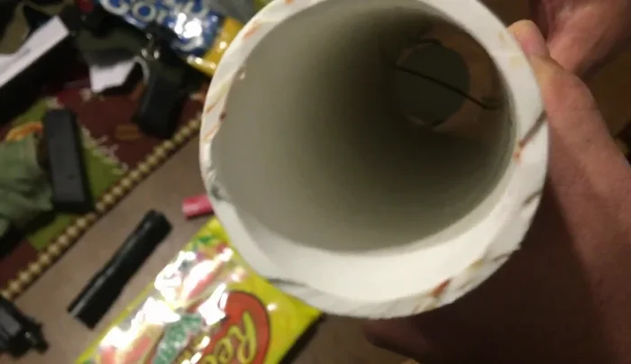 Pulling the trigger forward to launch the projectile.