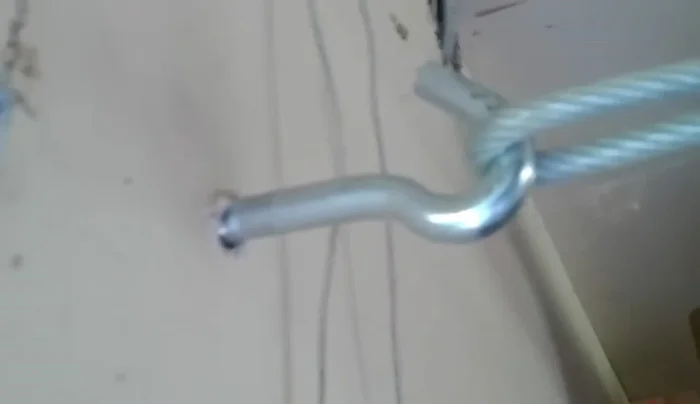 Bolt the eye hook securely into the wall joists, repeating on both ends.