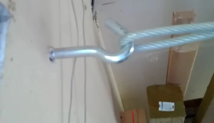 Bolt the eye hook securely into the wall joists, repeating on both ends.