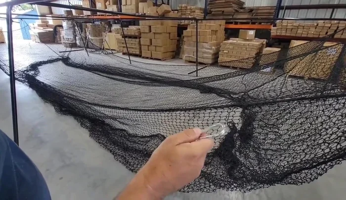 Attach the net to the frame using carabiner clips. Secure each rope border to a fitting.